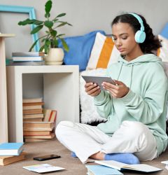teenager listening to a tablet in her room